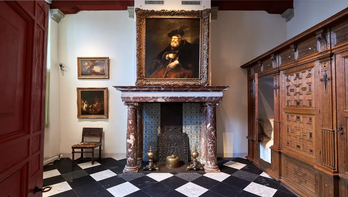 Historic 17th-century brick house in Amsterdam where Rembrandt lived and worked, with visitors entering the restored museum.