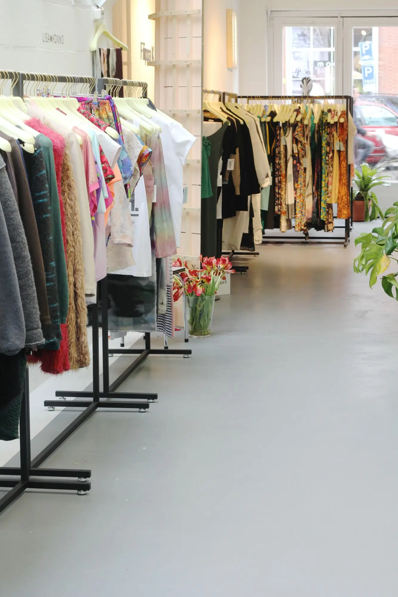 Interior of LENA fashion library showing curated racks for renting sustainable clothing.